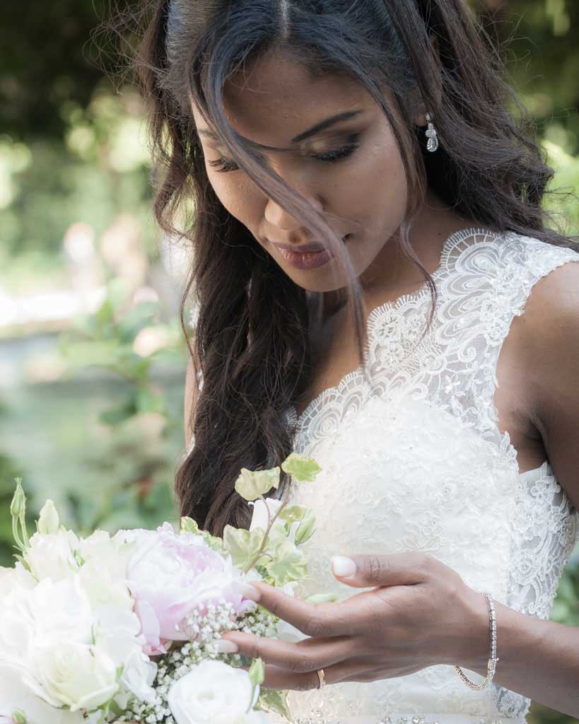 ritratto sposa esotica mentre accarezza il bouquet